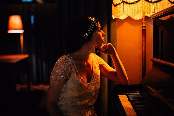 Frau im Flapperdress, nachdenklich am Klavier