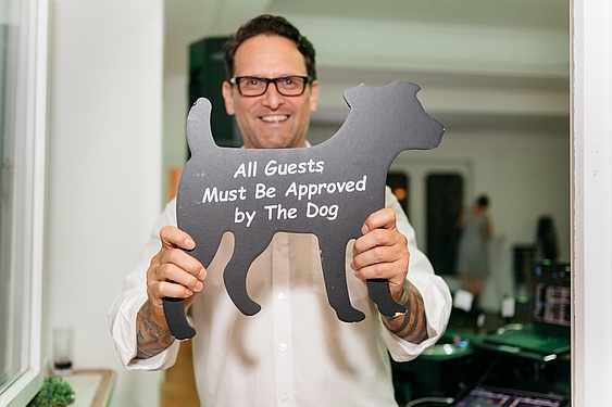 DJ Sam André, Hochzeits-DJ aus München live auf einer Hochzeit. Porträtfoto mit dem Schild: All guest must be approved by the dog 
